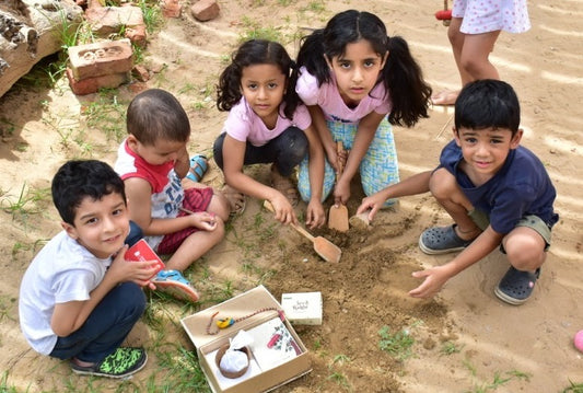 kids sowing seed rakhi into soil